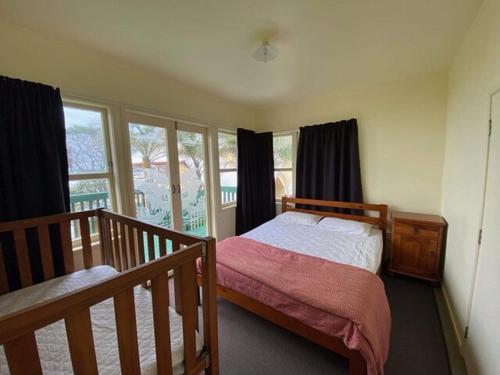 a bedroom with a bed and a window at KBHH - Beachfront Paradise - BUR1 in Ohope Beach