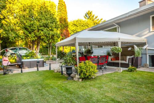 a backyard with a gazebo with chairs and tables at Nature Oasis Bar Room in Dundas