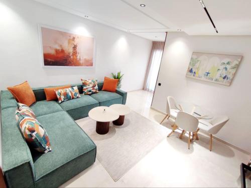 a living room with a green couch and a table at Studio Confortable et Cozy - Maarif Casablanca in Casablanca