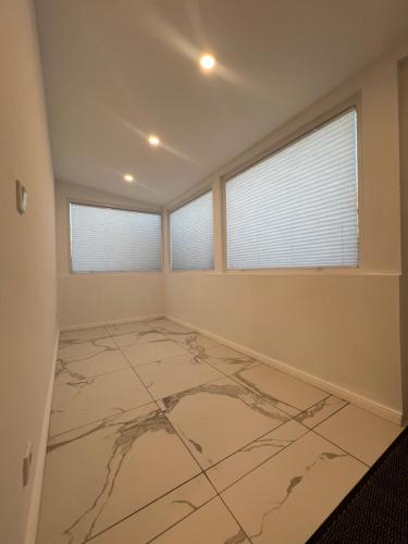 a large room with a marble floor and windows at Haus am Park Dreieich in Dreieich