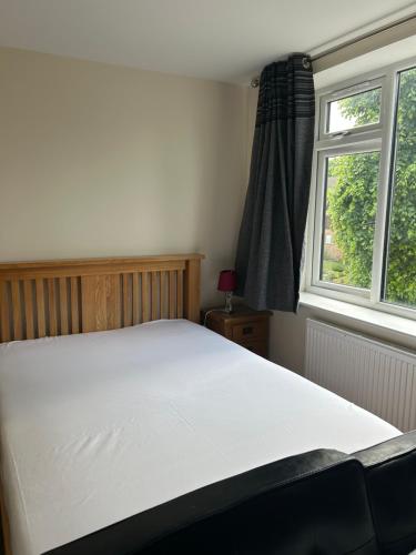 a bedroom with a large white bed in front of a window at 3 Green Cloth in Hackington