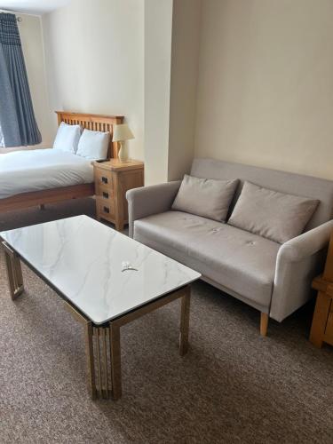 a living room with a couch and a coffee table at 3 Green Cloth in Hackington
