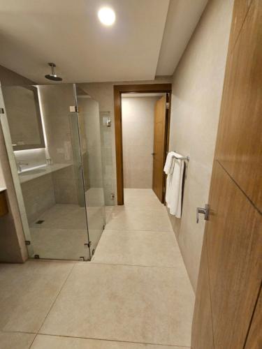 a bathroom with a walk in shower and a glass door at Hotel La Mariposa in Manuel Antonio