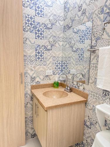 a bathroom with a sink and blue and white tiles at Casa Mía Rivera in Rivera