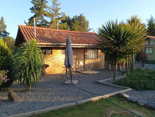 a house with an umbrella and a table and an umbrella at Eco Cabañas Algarrobo in Algarrobo