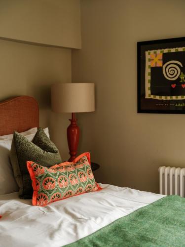 a bedroom with a bed with a pillow and a lamp at The Fleur de Lys in Cranborne