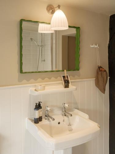 a bathroom with a sink and a mirror at The Fleur de Lys in Cranborne