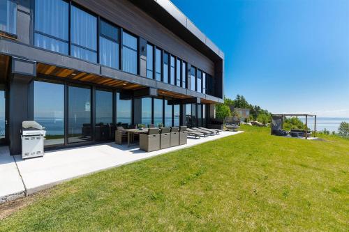 een groot gebouw met een gazon ervoor bij Chalet L'Eaurizon Charlevoix in La Malbaie