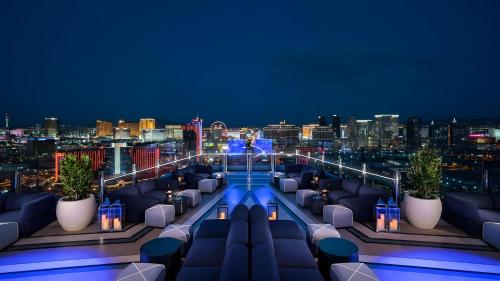 a rooftop bar with couches and a city skyline at night at Palms Place in Las Vegas
