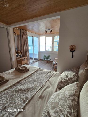 a bedroom with a large bed and a large window at BEACH Arguineguin SEA VIEW 7 CHG FAMILY HOTEL in Arguineguín