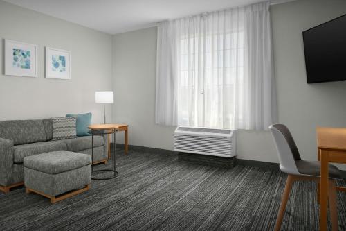 a living room with a couch and a window at TownePlace Suites by Marriott Albuquerque Airport in Albuquerque