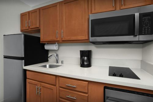 a small kitchen with a sink and a microwave at TownePlace Suites by Marriott Albuquerque Airport in Albuquerque
