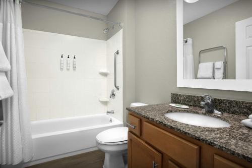 a bathroom with a sink and a toilet and a tub at TownePlace Suites by Marriott Albuquerque Airport in Albuquerque