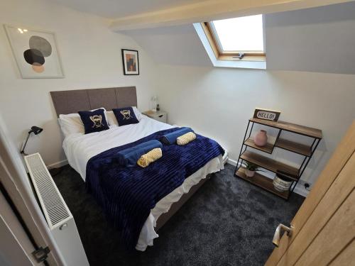 a bedroom with a bed with blue sheets and a window at 5 Bed Cottage Free Parking in Stainforth