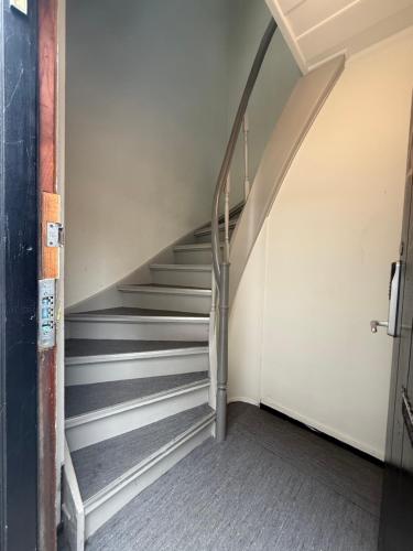 a staircase in an empty room with a stair case at Romslig leilighet midt i Bergen sentrum - komfort med kvalitetsenger og dyner in Bergen