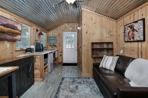 a living room with a couch and a kitchen at Pixie's Porch Tiny Home in Centerville