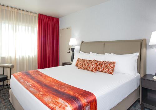a bedroom with a large bed with red curtains at Four Queens Hotel and Casino in Las Vegas