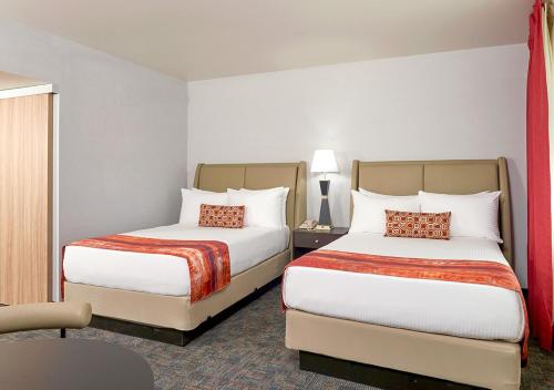 a hotel room with two beds and a chair at Four Queens Hotel and Casino in Las Vegas
