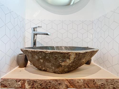 a bathroom with a stone sink with a faucet at Le Lodge de l'One in Luchon