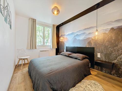a bedroom with a large bed and a painting on the wall at Le Lodge de l'One in Luchon