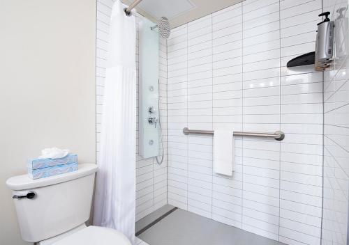 a white bathroom with a toilet and a shower at Four Queens Hotel and Casino in Las Vegas