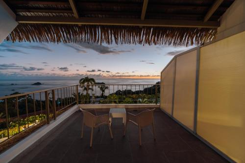 a balcony with a table and chairs and the ocean at Hotel La Mariposa in Manuel Antonio