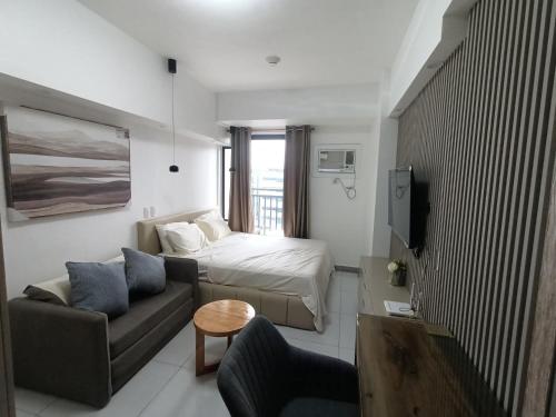 a small living room with a bed and a couch at Arc Tower Condominiums in Cebu City