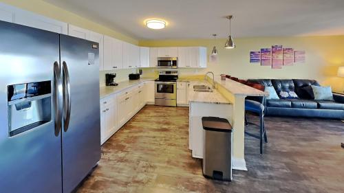 a kitchen with a stainless steel refrigerator and a couch at Put-in-Bay Waterfront Condo #103 in Put-in-Bay