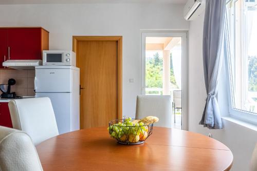 a bowl of fruit on a wooden table in a kitchen at Apartments Seaview in Tučepi