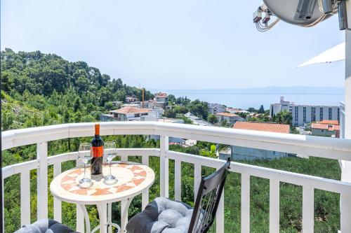 a table with a bottle of wine on a balcony at Apartments Seaview in Tučepi