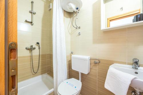 a bathroom with a shower and a toilet and a sink at Apartments Seaview in Tučepi
