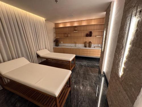 a hospital room with two tables and a tub at Flats New York in Itapema