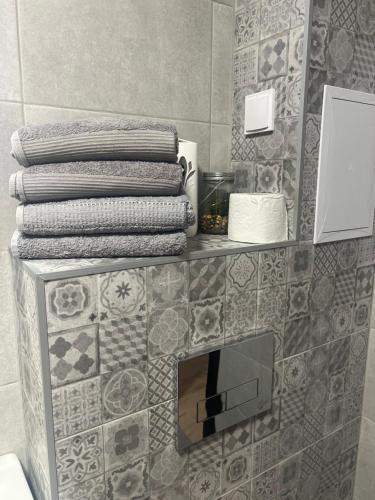 ein Stapel Handtücher auf einem Regal in einem Badezimmer in der Unterkunft Barceló Apartment Velingrad in Welingrad