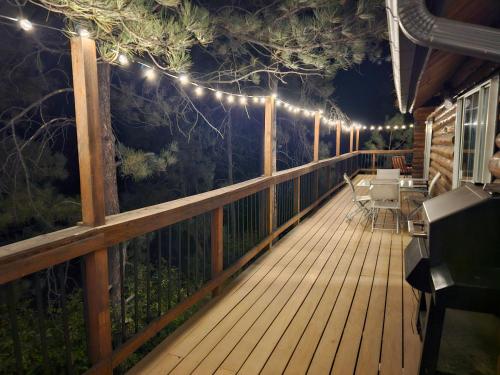 a wooden deck with lights on a fence at cabin in the woods with Hottub in Billings