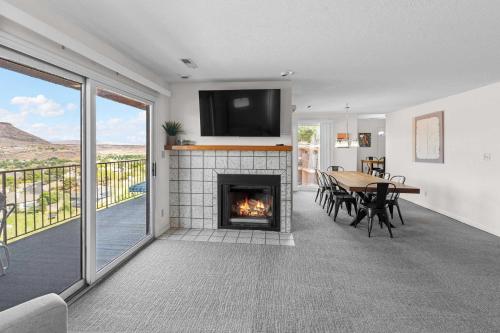 a living room with a fireplace and a table with chairs at Cozy Condo - Stay for 9 in St. George