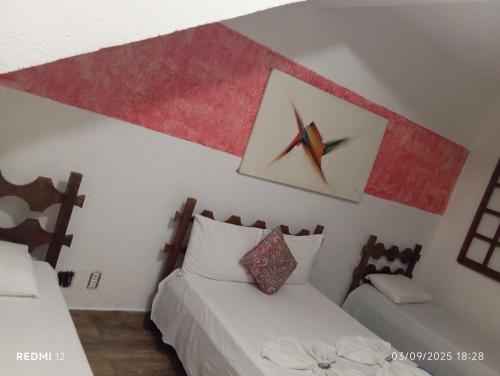 a bedroom with two beds and a clock on the wall at Pousada sollaris in Serra do Cipo
