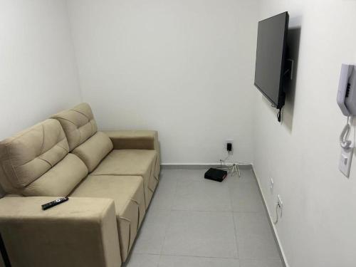 a living room with a couch and a flat screen tv at Apartamento Tibagy in Guarulhos