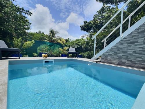 a swimming pool in a villa with a garden at Carambole se situe dans un quartier calme in Rivière-Salée