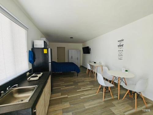 a kitchen with a sink and a refrigerator and tables at Lofts en Colonia Tec in Monterrey
