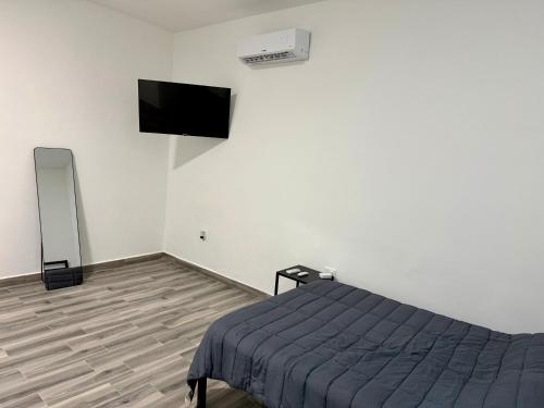 a bedroom with a bed and a tv on the wall at Lofts en Colonia Tec in Monterrey