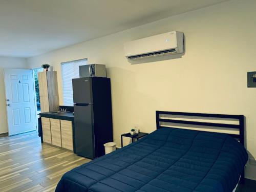 a bedroom with a blue bed and a refrigerator at Lofts en Colonia Tec in Monterrey