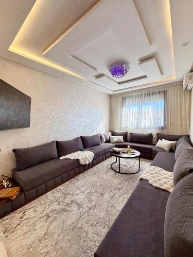 a living room with a couch and a table at Chic & Cozy Apartment in Tangier in Oulad Akkou