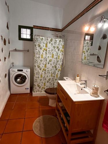 a bathroom with a sink and a washing machine at Bed&Ride La Manigua in Ojos de Garza