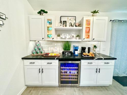 a kitchen with white cabinets and a black counter top at Coachella Private Pool Fire Pit BBQ with Chefs Kitchen in Indio
