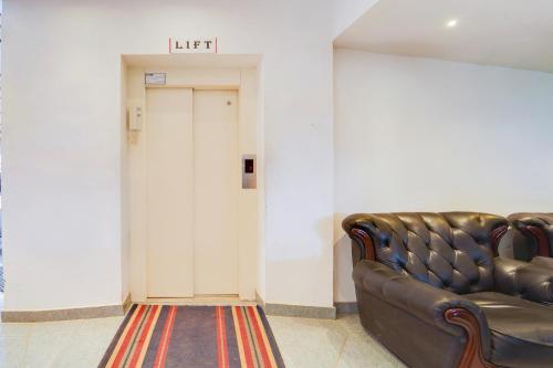 a leather couch in a waiting room with a lift at Super Hotel O Vazhakkala in Cochin