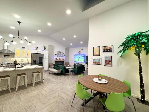 a kitchen and living room with a table and green chairs at Coachella Private Pool Fire Pit BBQ with Chefs Kitchen in Indio