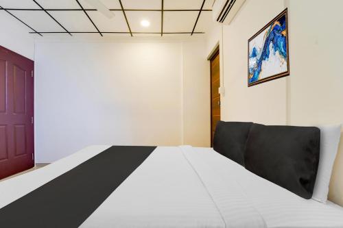 a bedroom with a bed and a black door at Super Hotel O Vazhakkala in Cochin