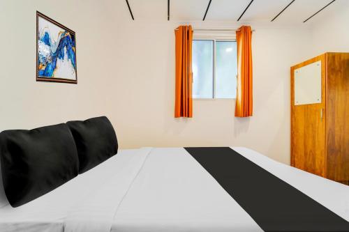 a bedroom with a black and white bed and a window at Super Hotel O Vazhakkala in Cochin