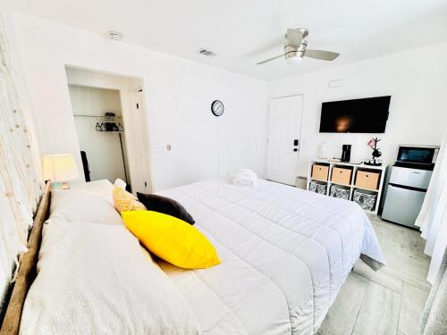 a white bedroom with two beds and a yellow pillow at Coachella Private Pool Fire Pit BBQ with Chefs Kitchen in Indio