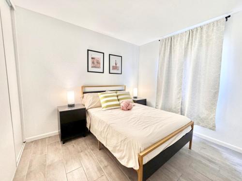 a bedroom with a bed with two night stands and a window at Coachella Private Pool Fire Pit BBQ with Chefs Kitchen in Indio